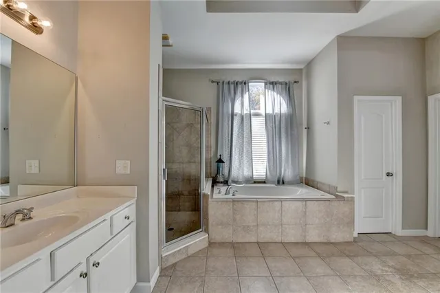 a bathroom with a tub a sink and mirror