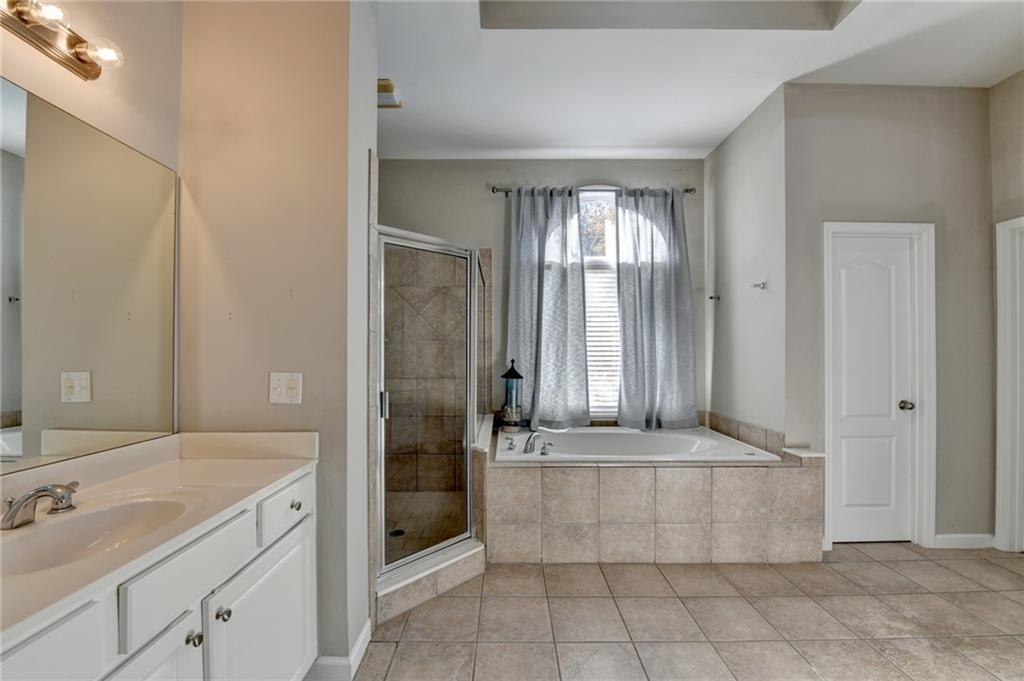 1601 Woodbow Crossing Dacula, GA 30019 - Photo 24 of 51 a bathroom with a tub a sink and mirror