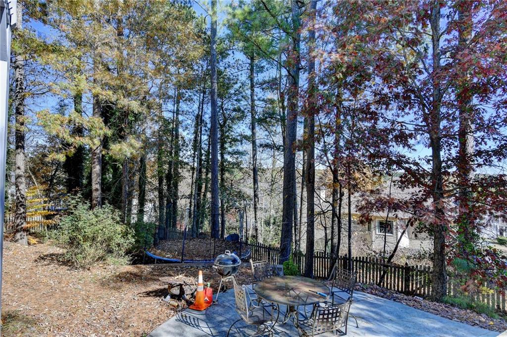 1601 Woodbow Crossing Dacula, GA 30019 - Photo 41 of 51 a view of a patio with table and chairs under an umbrella