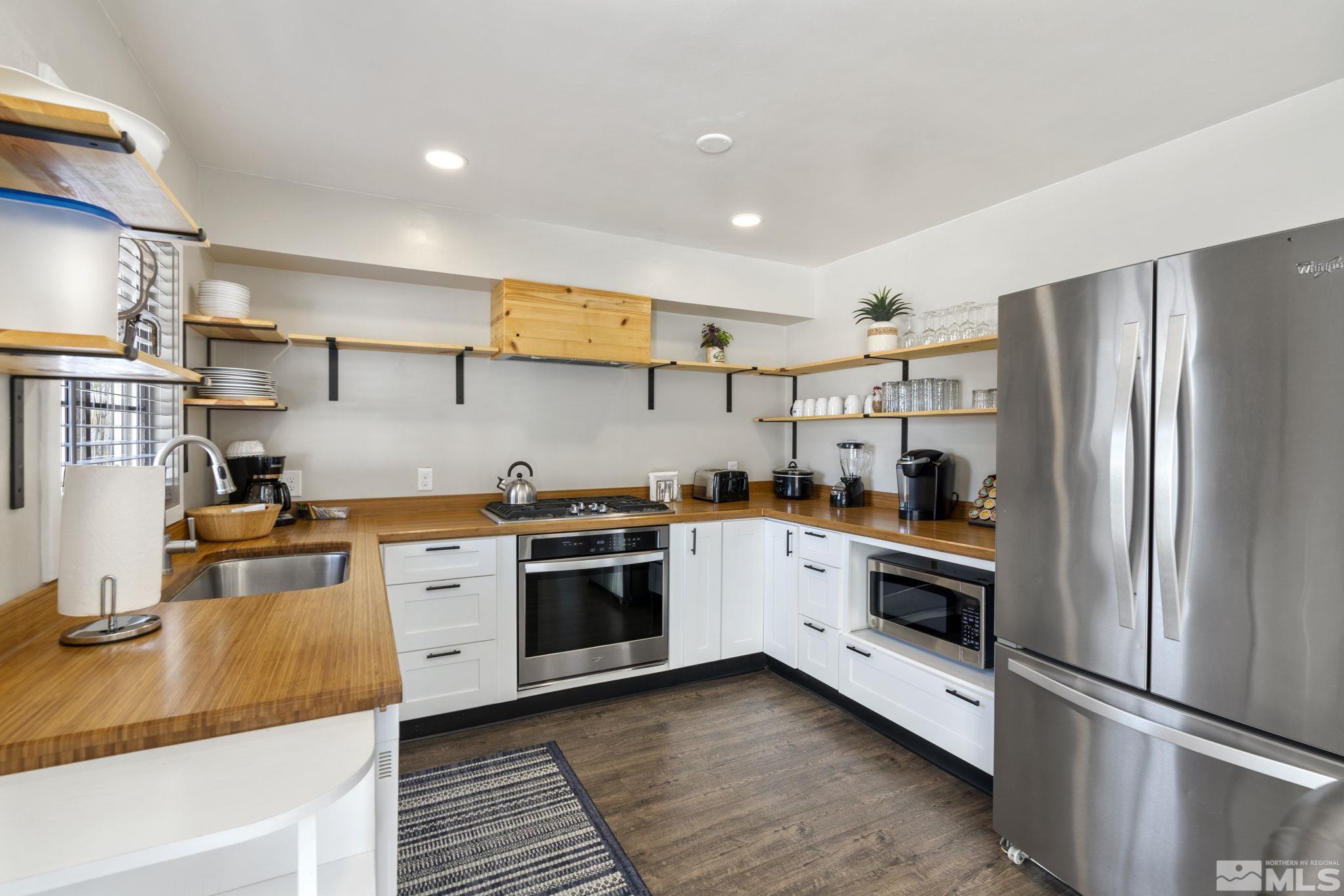 840 Bates Avenue Reno, NV 89502 - Photo 10 of 39 a kitchen with stainless steel appliances granite countertop a refrigerator a stove and a sink with wooden floor