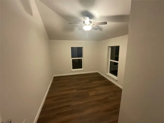 a view of a hallway with wooden floor and chandelier