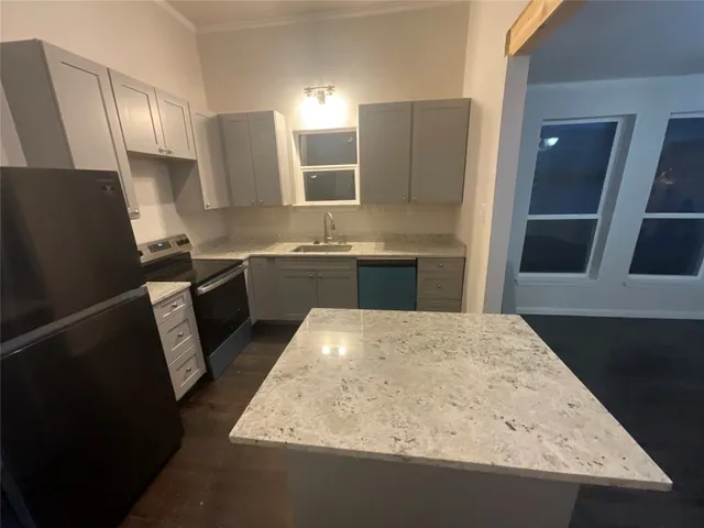 a kitchen with stainless steel appliances granite countertop sink stove and refrigerator