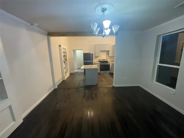 a view of a livingroom with wooden floor fireplace and window