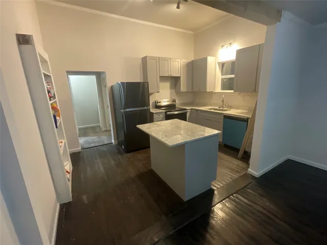 a kitchen with sink a refrigerator and wooden floor