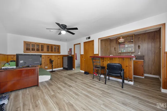 a living room with furniture and a dining table with wooden floor
