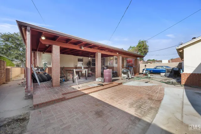a view of a patio with dining table and chairs under an umbrella