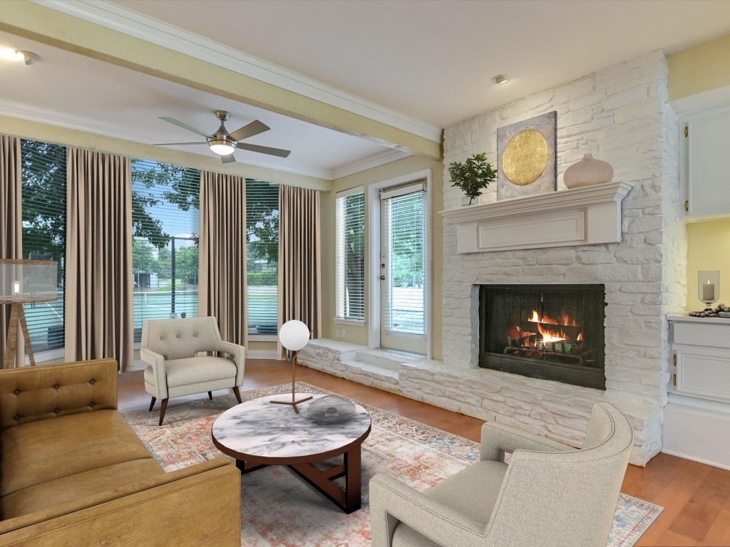 Spacious living room with wood burning fireplace, a wall of windows and a dry bar with built-in cabinetry.