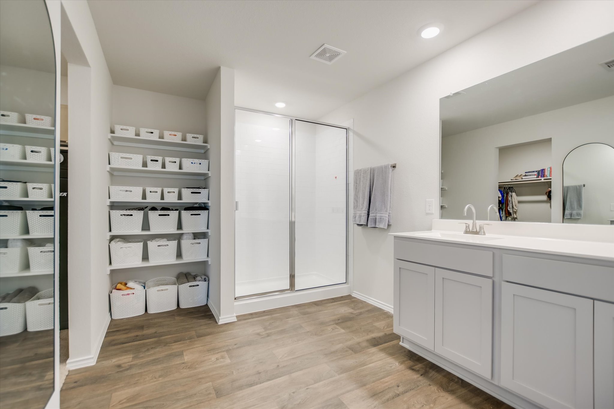 262 Sickle Loop Kyle, TX 78640 - Photo 10 of 20 Bathroom featuring a walk in closet, light wood-style flooring, vanity, a shower stall, and recessed lighting