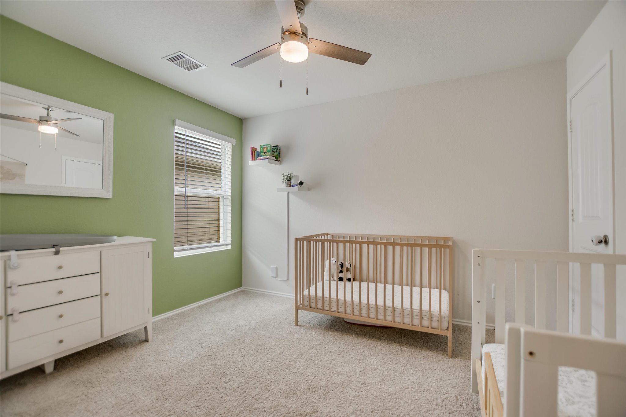 262 Sickle Loop Kyle, TX 78640 - Photo 13 of 20 Bedroom with a crib, light colored carpet, and ceiling fan