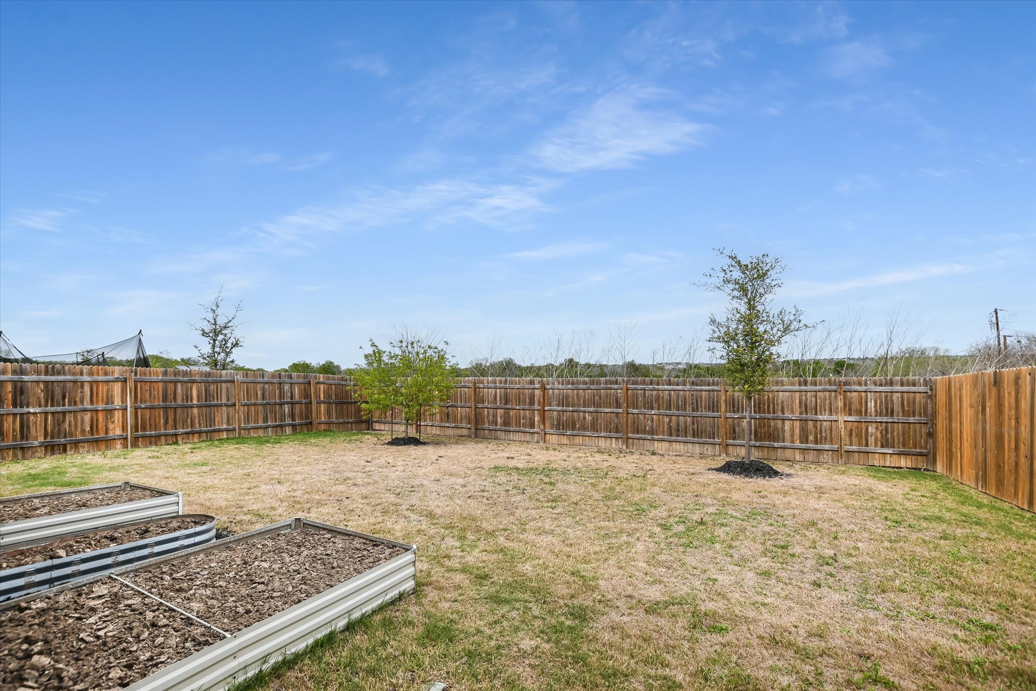 262 Sickle Loop Kyle, TX 78640 - Photo 17 of 20 Fenced backyard with a vegetable garden