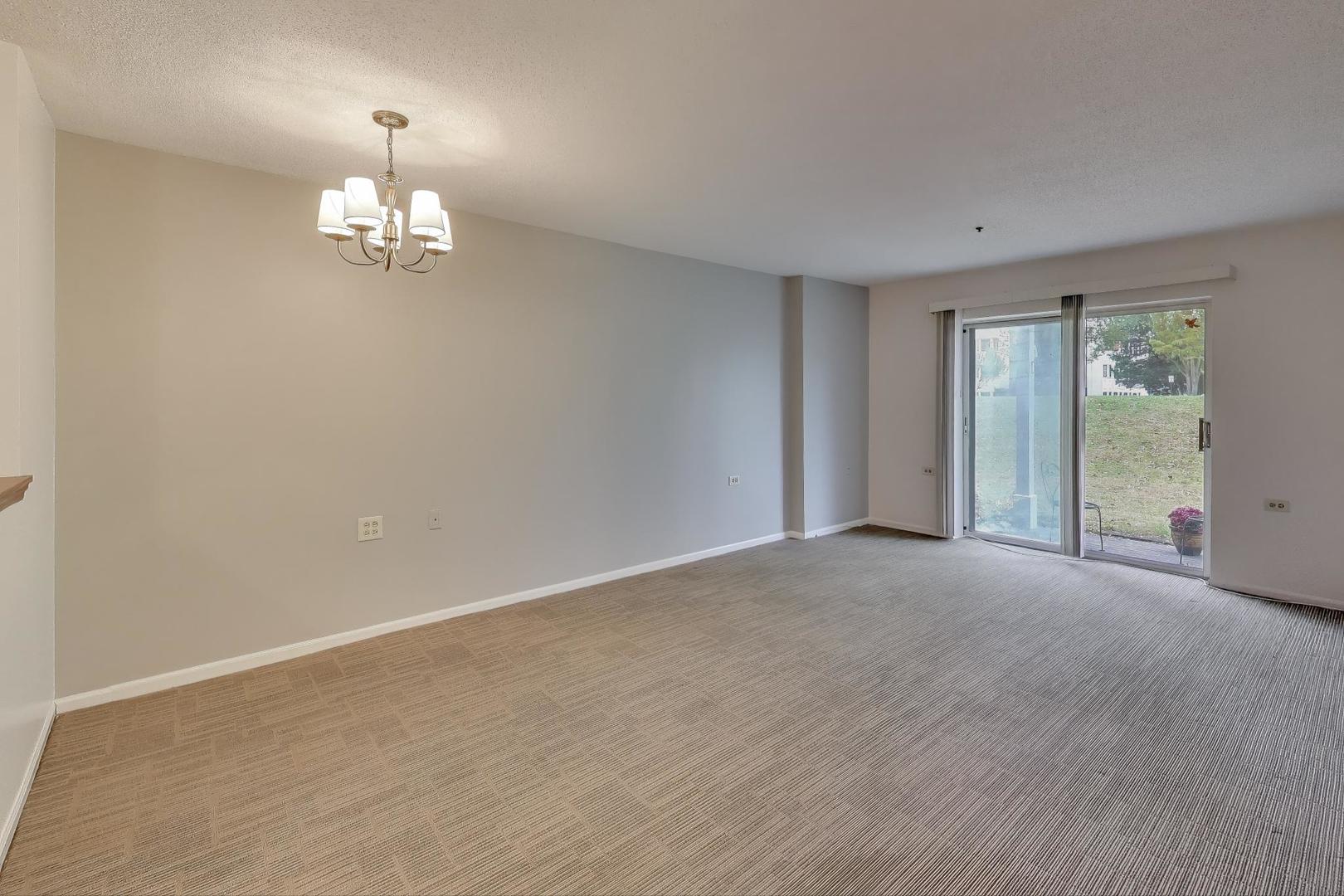 800 Ridge Road, Unit 114 Wilmette, IL 60091 - Photo 9 of 23 an empty room with a chandelier