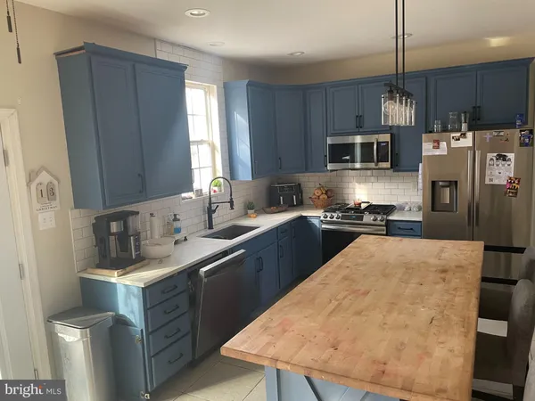 a kitchen with stainless steel appliances granite countertop a sink refrigerator and microwave