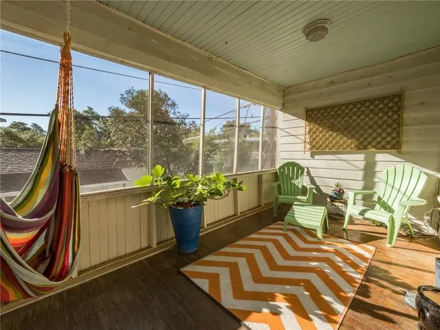 a balcony with chairs and potted plants