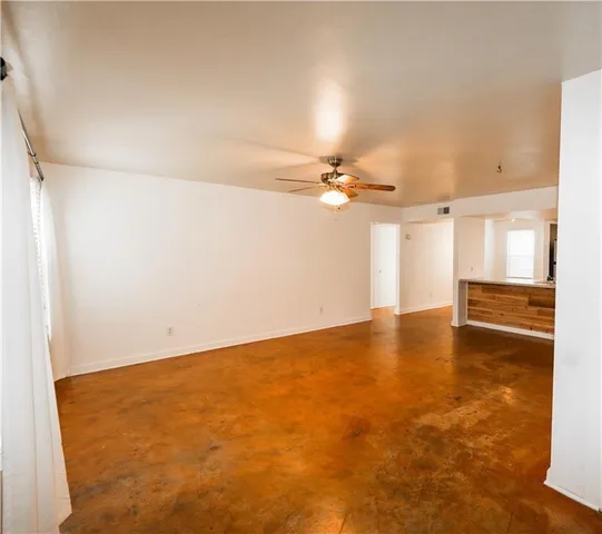 an empty room with a empty space and kitchen view