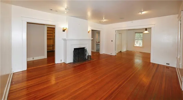 a view of empty room with wooden floor and fireplace