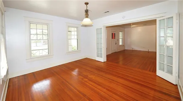 a view of empty room with wooden floor and fan