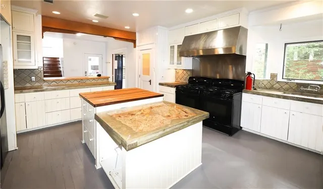 a kitchen with stainless steel appliances kitchen island granite countertop a sink and a stove
