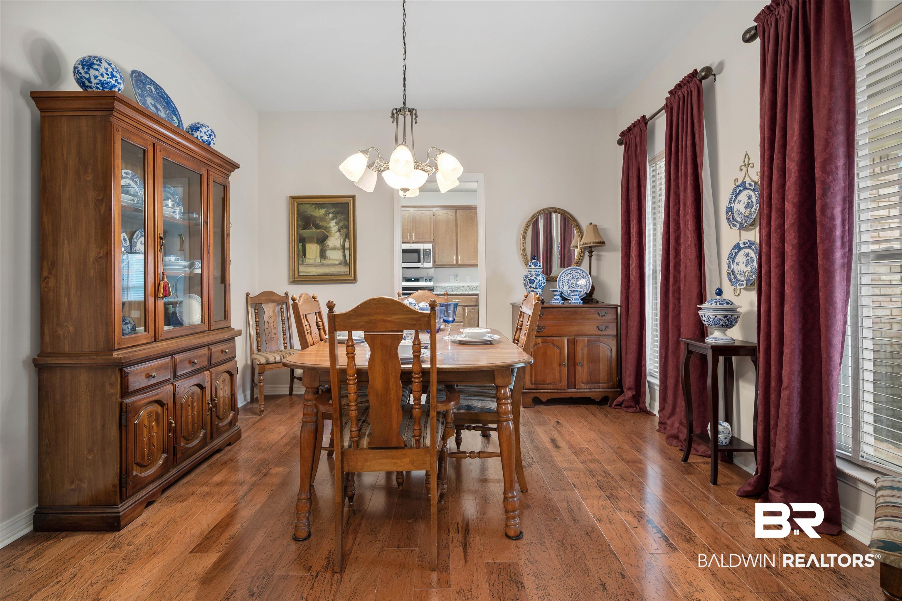 7419 Pake Road Saraland, AL 36571 - Photo 12 of 27 Dining area featuring hardwood / wood-style floors and a chandelier