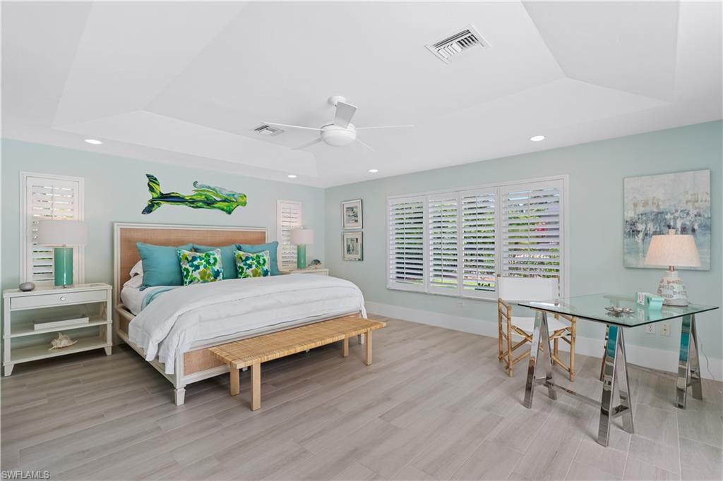 521 Turtle Hatch Road Naples, FL 34103 - Photo 12 of 34 a bedroom with a bed chandelier and a window
