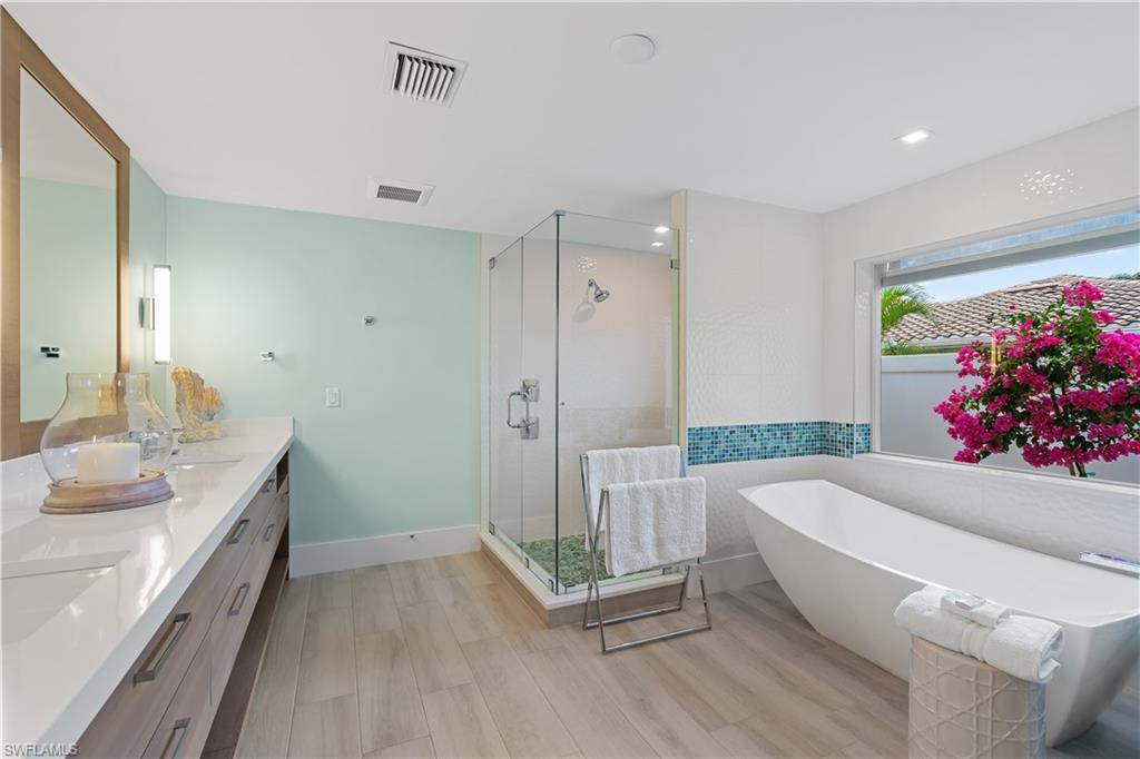 521 Turtle Hatch Road Naples, FL 34103 - Photo 16 of 34 a bathroom with a tub sink and mirror