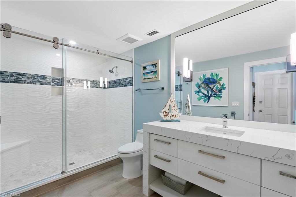521 Turtle Hatch Road Naples, FL 34103 - Photo 23 of 34 a bathroom with a granite countertop sink a toilet and a mirror