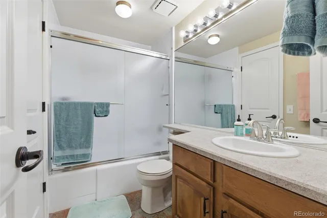 a bathroom with a sink a toilet a mirror and shower