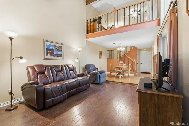 a living room with furniture a flat screen tv and a wooden floor