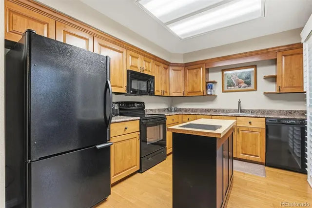 a kitchen with stainless steel appliances granite countertop a refrigerator a stove a sink and a microwave