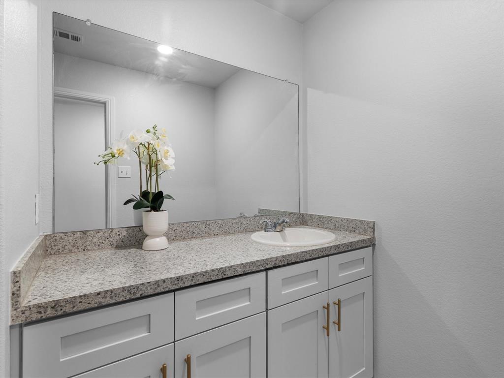 401 Attalla Street Azle, TX 76020 - Photo 19 of 24 a bathroom with a granite countertop sink and a mirror