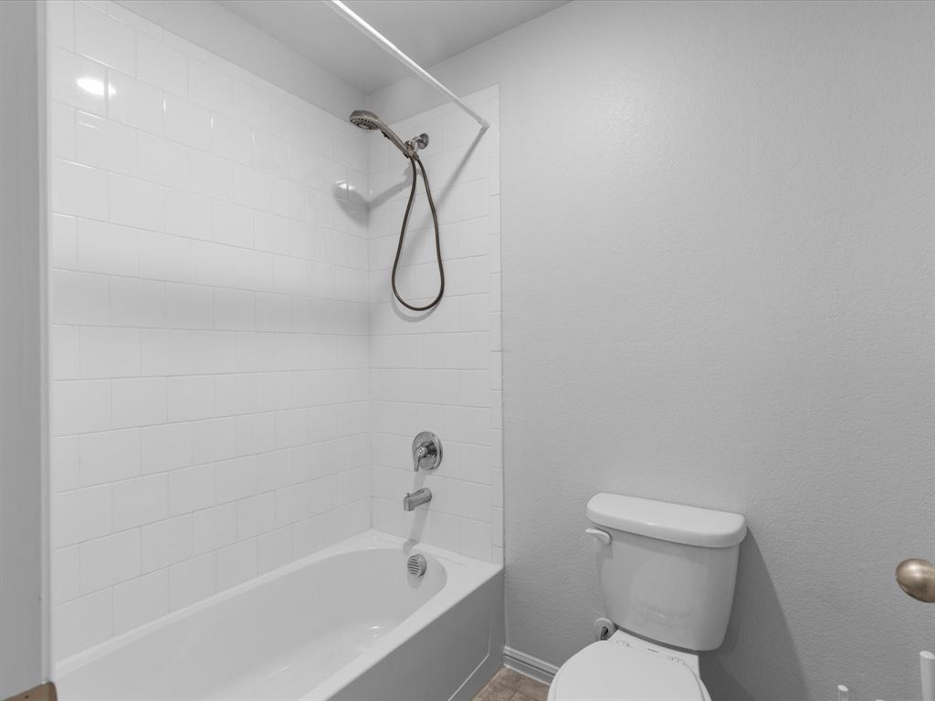 401 Attalla Street Azle, TX 76020 - Photo 20 of 24 a white toilet sitting next to a bath tub