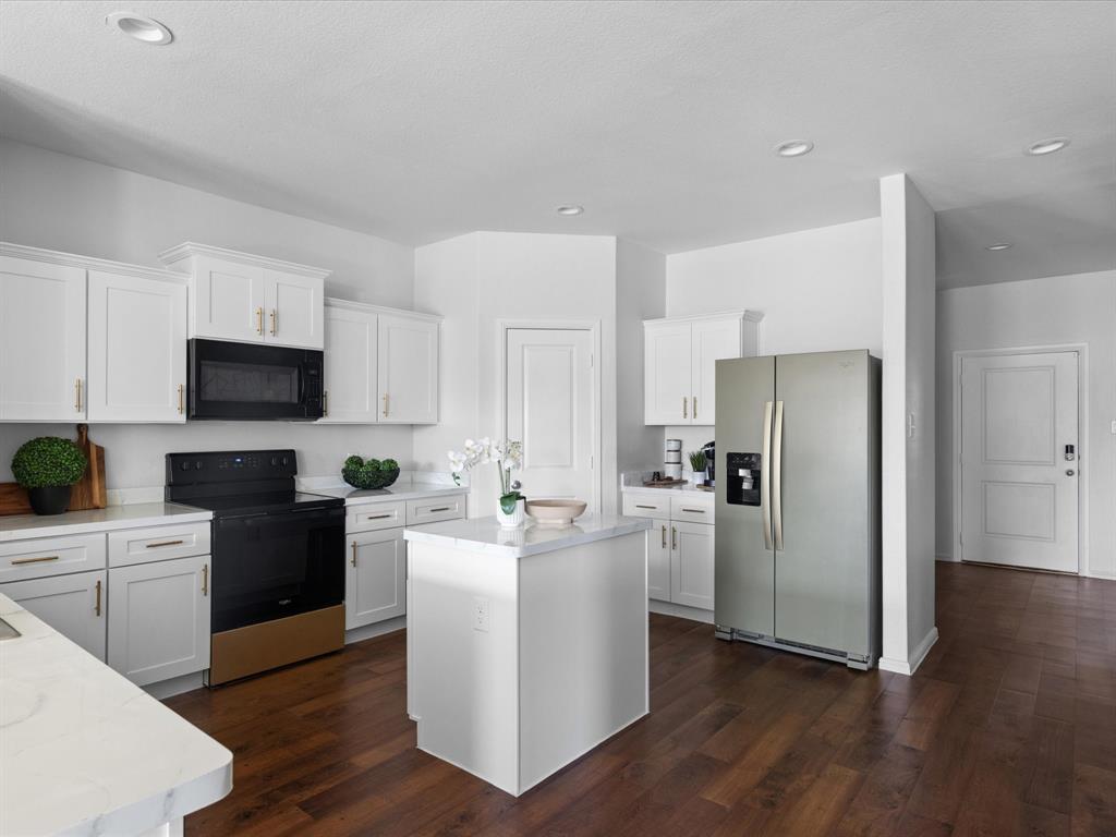 401 Attalla Street Azle, TX 76020 - Photo 7 of 24 a kitchen with stainless steel appliances a refrigerator stove a sink and white cabinets with wooden floor