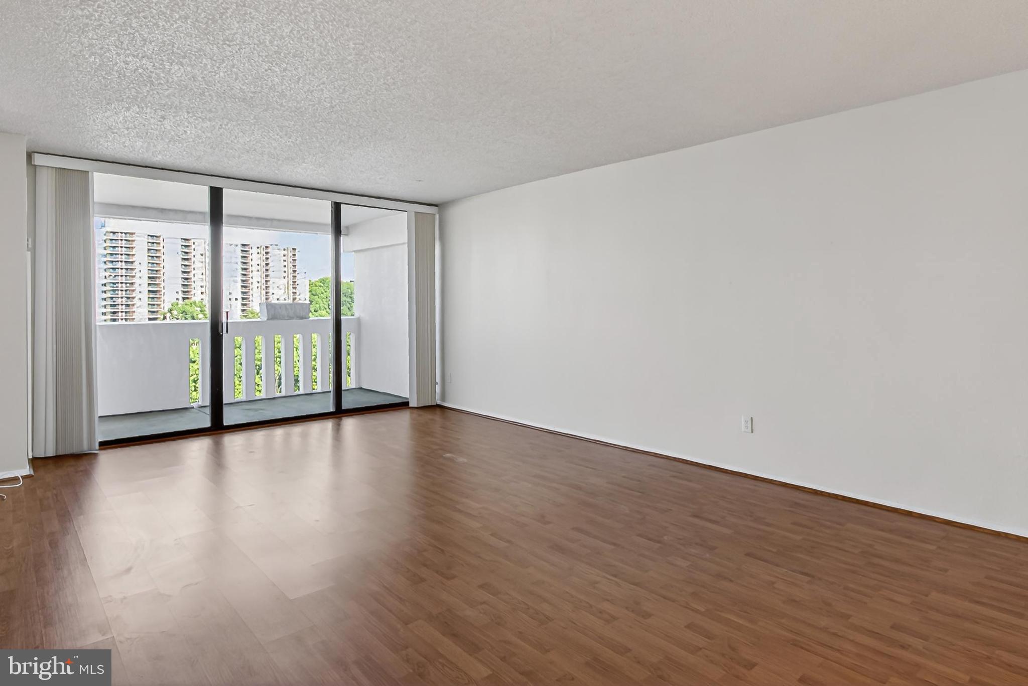 6101 Edsall Road, Unit 1206 Alexandria, VA 22304 - Photo 13 of 52 a view of an empty room with wooden floor and a window
