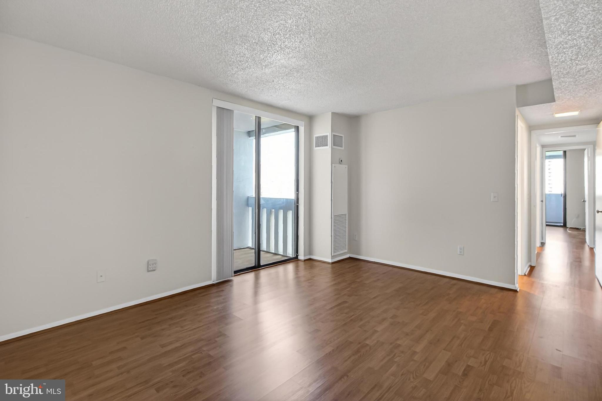 6101 Edsall Road, Unit 1206 Alexandria, VA 22304 - Photo 24 of 52 a view of an empty room with wooden floor and a window