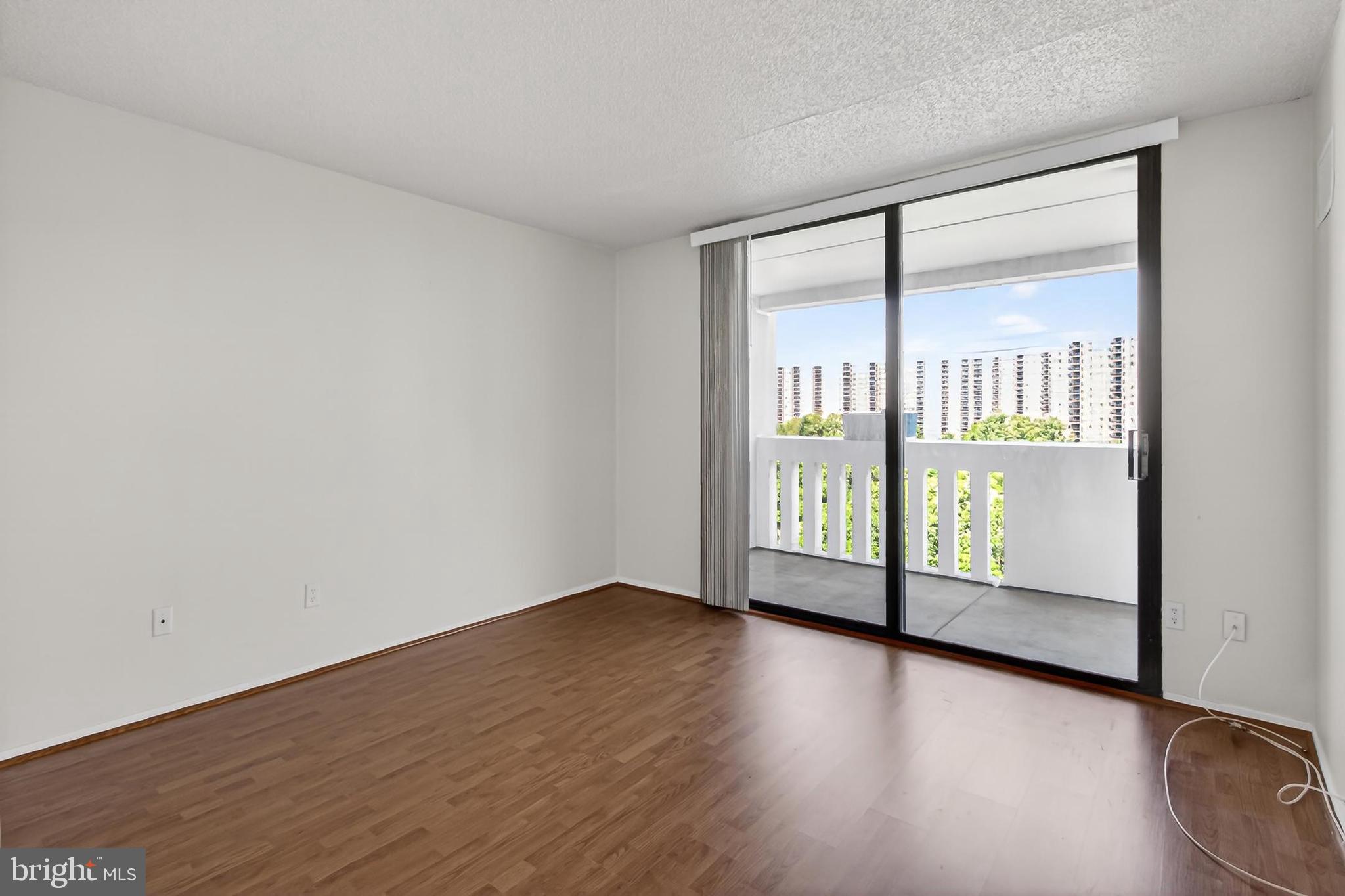 6101 Edsall Road, Unit 1206 Alexandria, VA 22304 - Photo 31 of 52 a view of an empty room with wooden floor and a window
