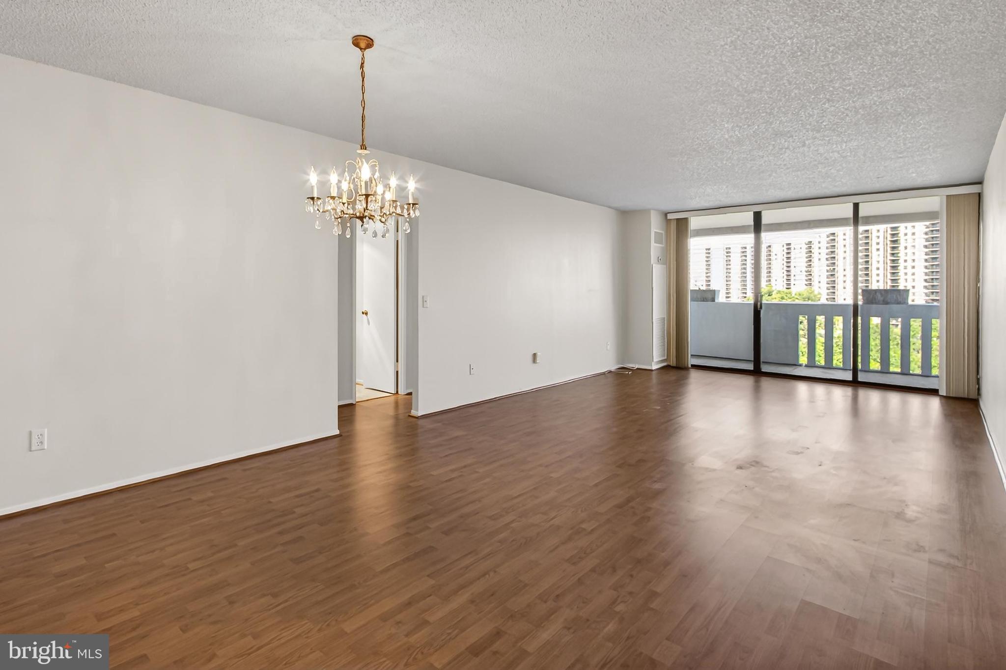 6101 Edsall Road, Unit 1206 Alexandria, VA 22304 - Photo 9 of 52 a view of a livingroom with wooden floor staircase and a chandelier