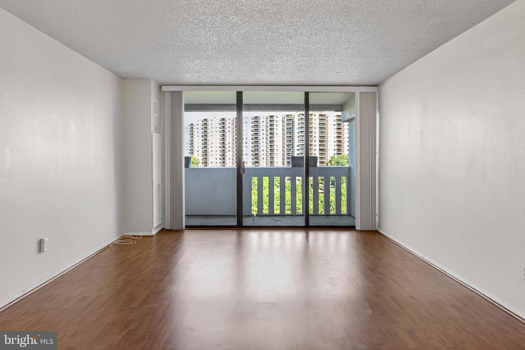 6101 Edsall Road, Unit 1206 Alexandria, VA 22304 - Photo 10 of 52 a view of an empty room with wooden floor and a window