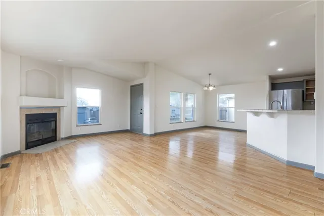 a view of a livingroom with wooden floor and a kitchen