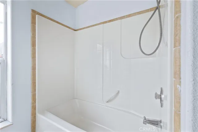 an empty room with a window and ceiling fan