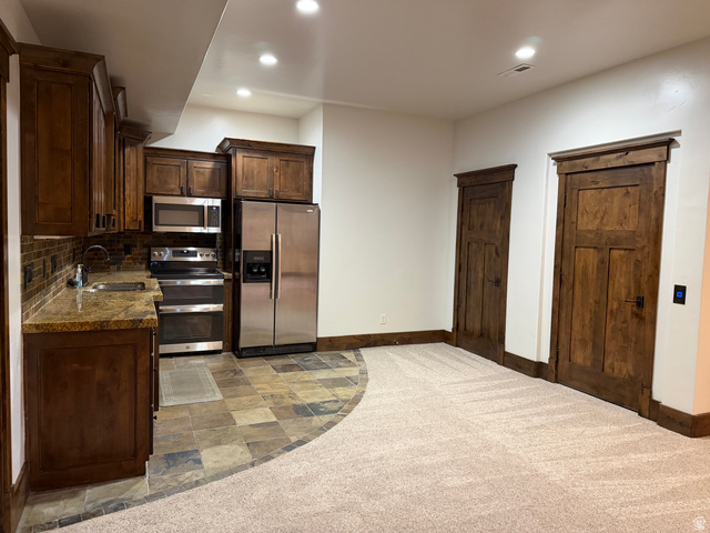 4536 North 475 East Provo, UT 84604 - Photo 16 of 65 Kitchenette featuring dark wood cabinetry, stainless steel appliances, granite countertops, and a mosaic tile backsplash