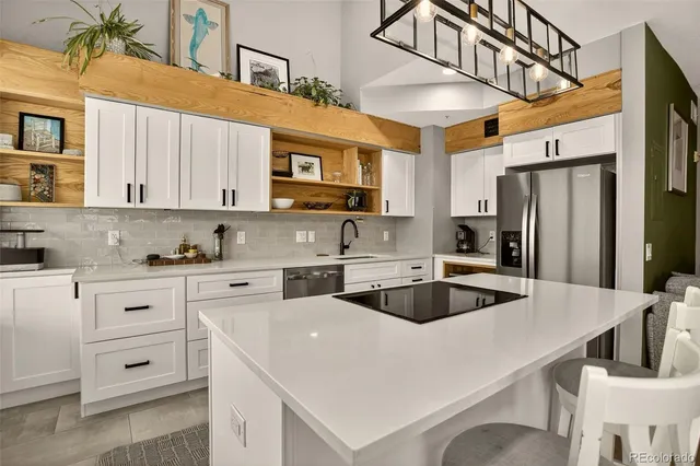 a kitchen with stainless steel appliances a sink a stove a refrigerator and cabinets
