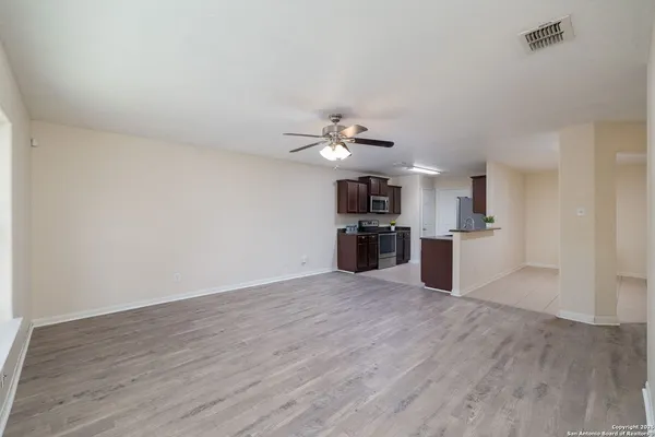 a view of kitchen with refrigerator microwave and wooden floor