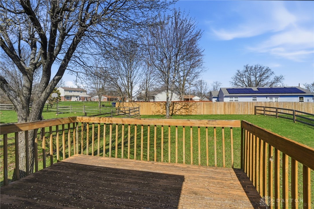 280 Stillpass Way Monroe, OH 45050 - Photo 45 of 49 This spacious yard features a wooden deck and fencing, with solar panels visible on a nearby roof.