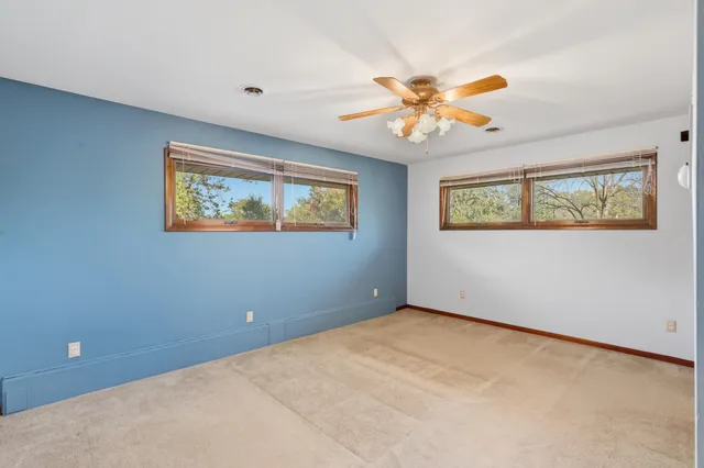 en empty room with window ceiling fan and a window