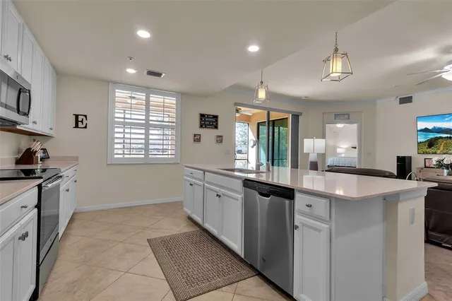 a large kitchen with kitchen island a sink stainless steel appliances and a counter top space