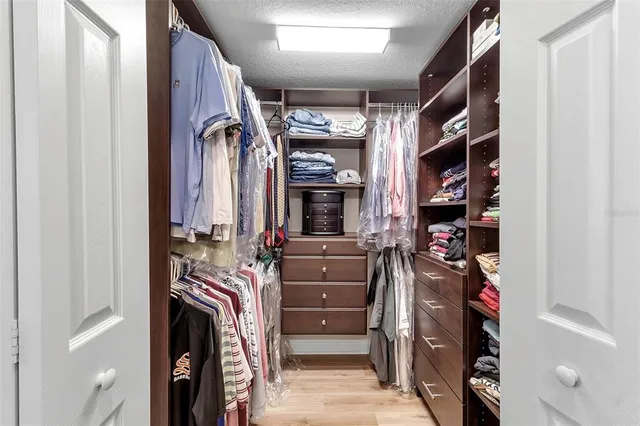 a view of walk in closet with clothes