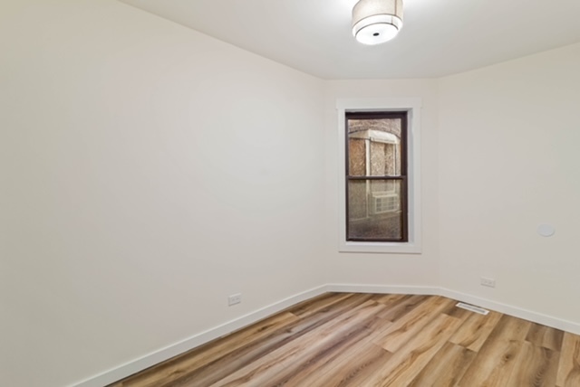 1018 North Harding Avenue Chicago, IL 60651 - Photo 13 of 38 a view of an empty room with wooden floor and a window