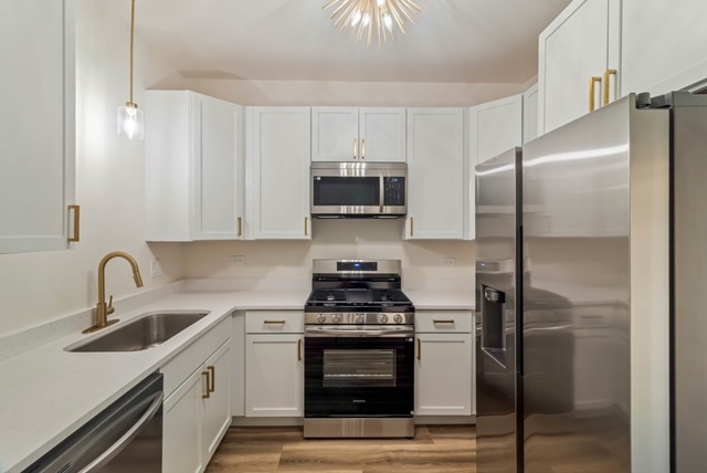 1018 North Harding Avenue Chicago, IL 60651 - Photo 26 of 38 a kitchen with stainless steel appliances a stove a sink and a refrigerator