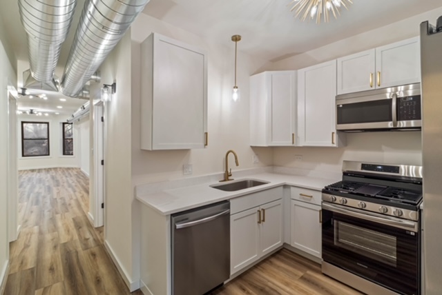 1018 North Harding Avenue Chicago, IL 60651 - Photo 27 of 38 a kitchen with stainless steel appliances granite countertop a stove and a microwave
