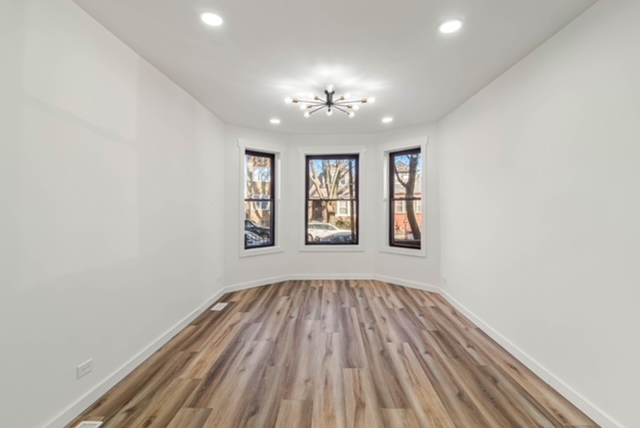 1018 North Harding Avenue Chicago, IL 60651 - Photo 3 of 38 wooden floor in an empty room with a window