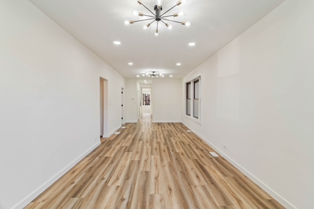 1018 North Harding Avenue Chicago, IL 60651 - Photo 5 of 38 a view of an empty room with wooden floor and a ceiling fan